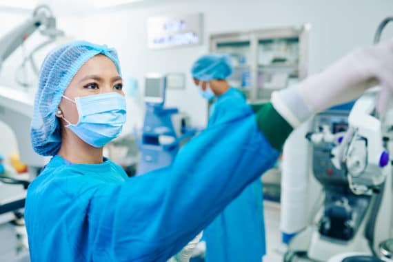Surgeon assistant turning on equipment in operating room